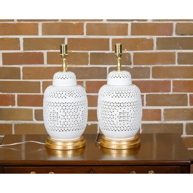 A pair of white porcelain vases with pierced geometric décor from circa 1920 made into table lamps wired for the USA and...
