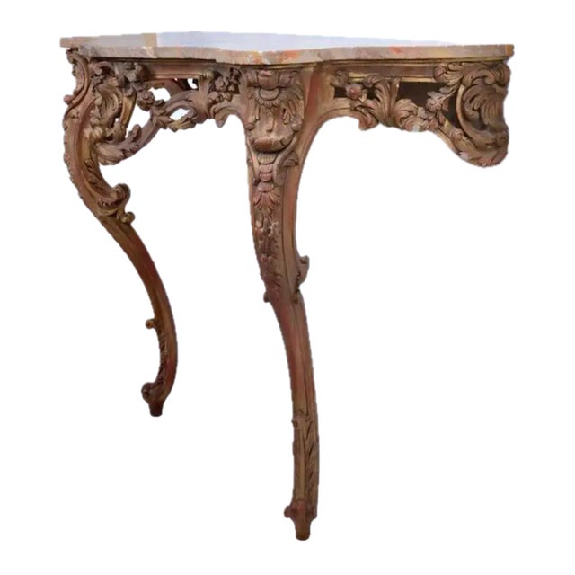 Antique Italian giltwood wall mounted console table in the Rococo taste, each having a shaped marble top, robustly carved...