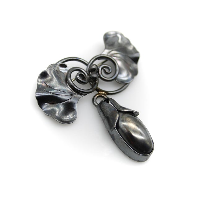 In a style that Georg Jenson’s work is known for, the body of this sterling silver brooch consists of swirling gingko...