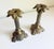 A classic pair of vintage ornate cast brass candlesticks featuring fluted neoclassical columns and stylized palm leaf or...