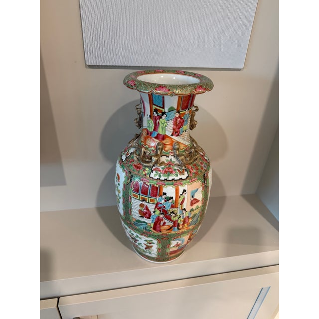 A striking Chinese porcelain vase featuring colorful hand-painted figural scenes set within ornate decorative panels,...