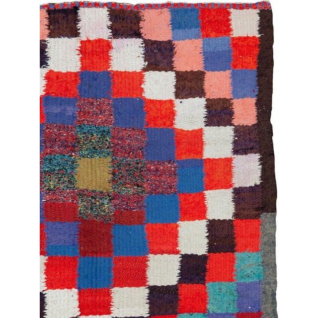 This mid-20th century Persian flatweave kilim rug presents a bold, graphic composition rooted in tribal weaving tradition....