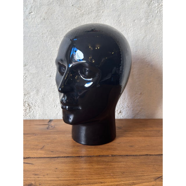 A striking vintage ceramic mannequin head dating from the 1970s, finished in a deep, high-gloss black glaze. with its...