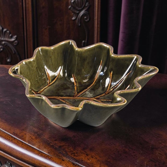 The Glazed Ceramic Olive Green Leaf Shaped Roscher Serving Bowl is a unique and stylish piece of dinnerware that adds a...