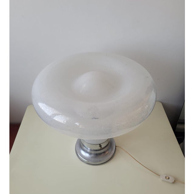 A refined table lamp in blown Murano glass, with an organic and sinuous shape reminiscent of Angelo Mangiarotti's iconic...