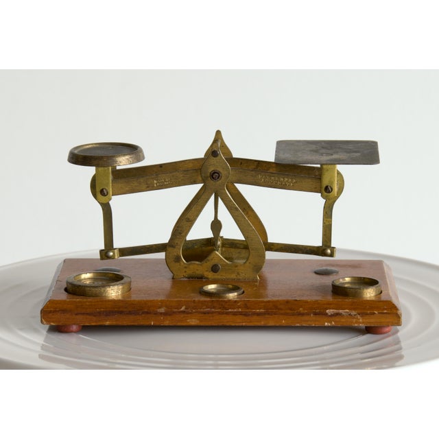 An English brass postal scale on its original hardwood base, of the type that sat on desks and in post offices when...