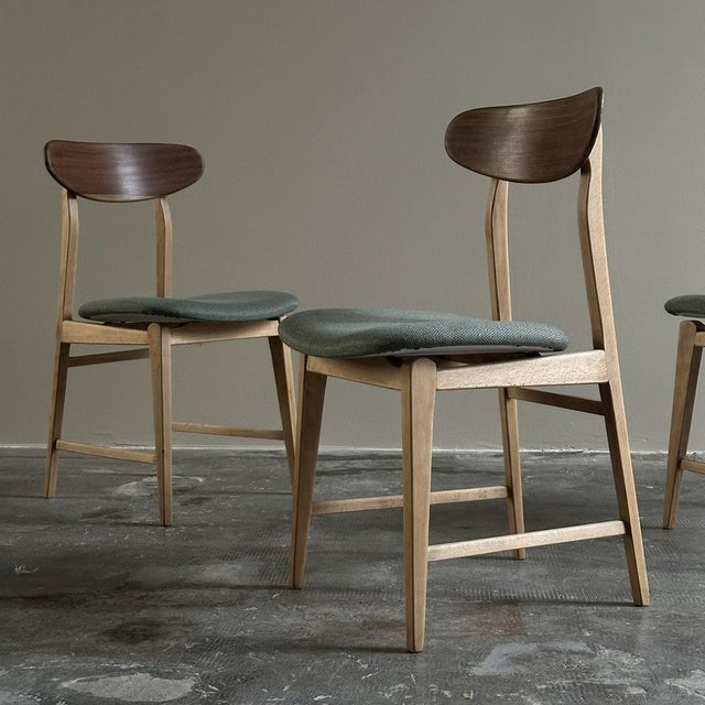 Set of four chairs from the 1960s. The chairs have a light wood frame, with upholstered seats covered in light green...