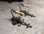 Matching set of single-arm black wrought iron sconces with scrollwork backplates and beeswax-style candle covers; Spanish...