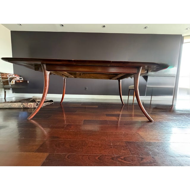 Depicted with one of its Two leaves, this Robsjohn-Gibbing's Mid Century Modern classic walnut saber leg extension dining...