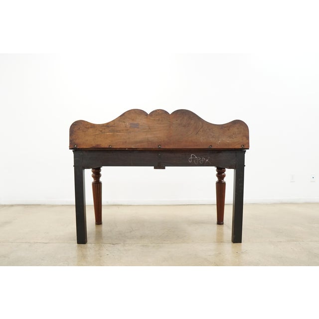 Vintage Federal style console table featuring a warm mahogany-toned finish, elegant fluted taper legs, and a sculptural...