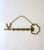 A brass wall key 'key' holder, circa mid-20th century. This brass wall key holder is designed in the shape of an antique...