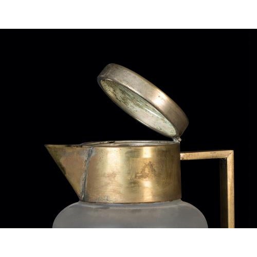 Vintage glass pitcher is a very beautiful decorative object in brass and glass, realized during the 1970s. A midcentury...
