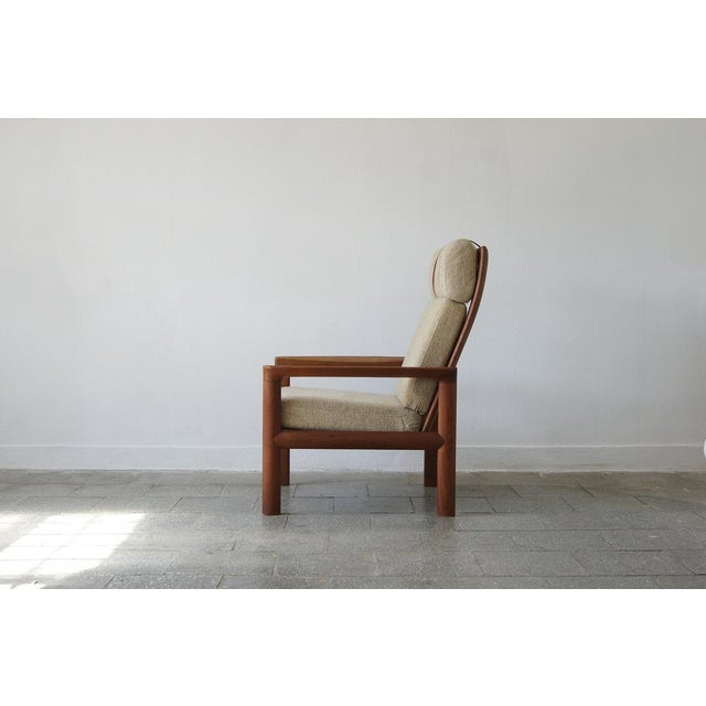 The minimalist teak frame and the wide, upholstered seat and back create a comfortable and striking armchair. The frame...