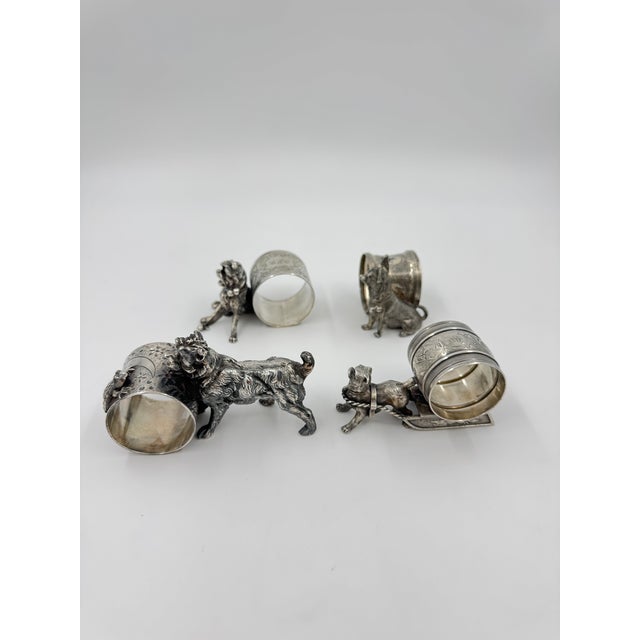 Set of 4 silver plated dog themed figural napkin rings. Each dog has different detailing on the ring. Two of the four have...