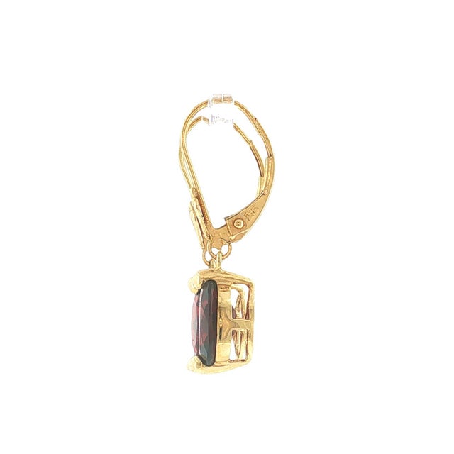 A pair of modern vintage 14k gold garnet dangle earrings. Each features 9x7mm oval-cut red garnets. The earrings have...