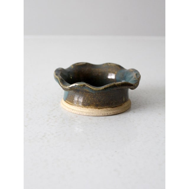 Bring organic character to your space with this vintage handmade pottery bowl, featuring a wavy, scalloped rim and a rich...