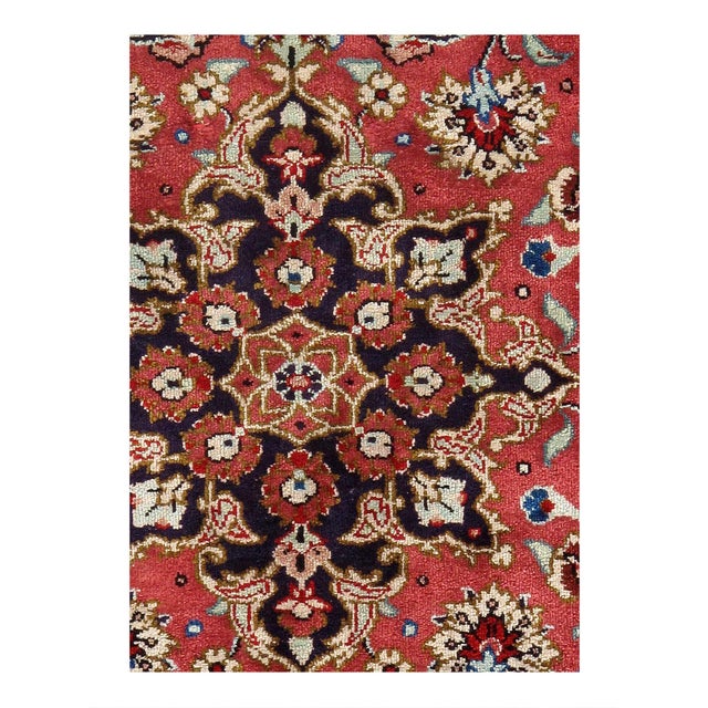 The dominant colors in this rug include rich shades of red, deep navy blue, vibrant Light green, soft ivory, and subtle...