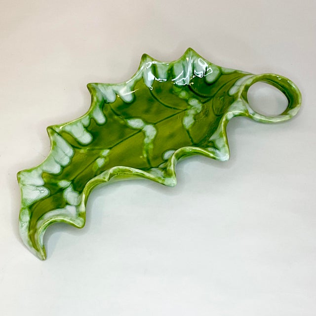 This is a gorgeous Folk Art ceramic Christmas serving or decorative dish. It’s has a lovely Holly Leaf shape with a self...