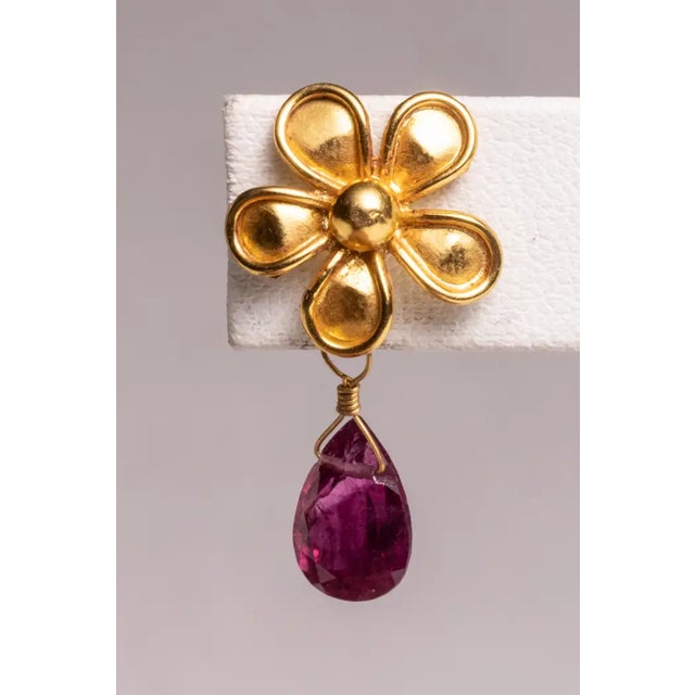 A lovely 22K gold flower post earring with a pear-shaped, faceted pink tourmaline briolette drop. For pierced ears. The...