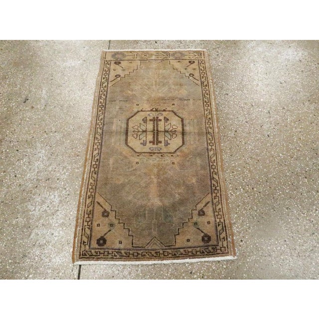 This Mid-20th century Turkish Oushak rug, exemplifies the enduring artistry of Anatolian weaving traditions, translated...
