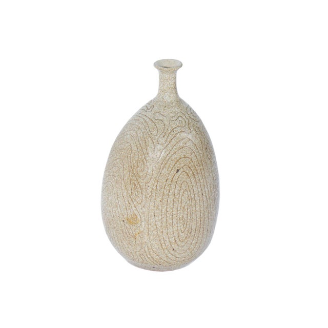 A studio pottery vase by American artist Frederick Carlton Ball (1911-1992). This neutral-colored bottle-shaped vase...