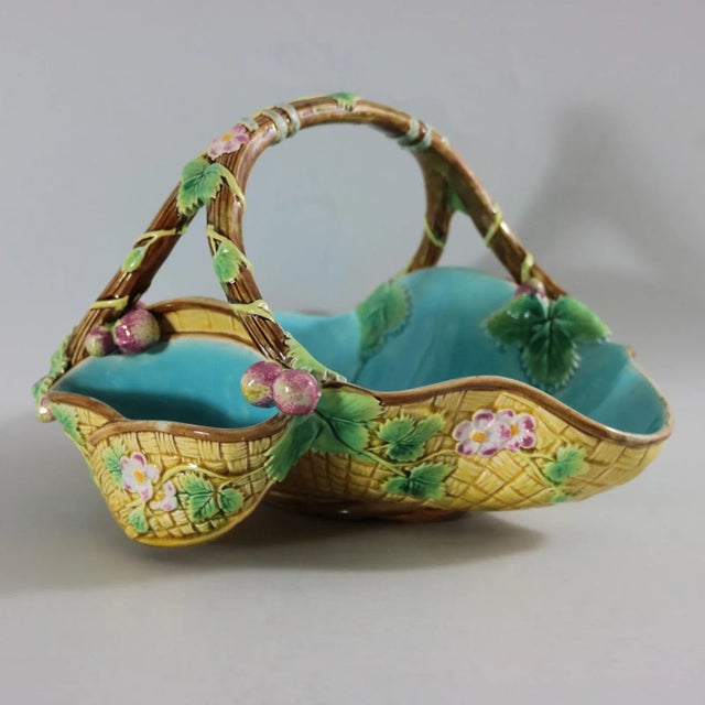 George Jones Majolica basket which features yellow woven basket sides and a branch handle. Embellished all over with...