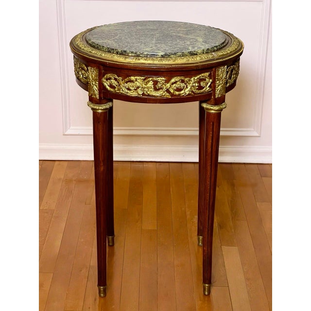 A fine French 19th century Louis XVI style mahogany gueridon side or occasional table with a dark green marble top...