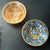 A collection of two small pottery bowls with polychrome central figurative decorations, matching size and similar conical...