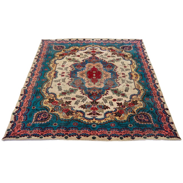 This Vintage Persian handmade Tabriz has a blue and beige field with multicolor accents throughout the design. This rug...
