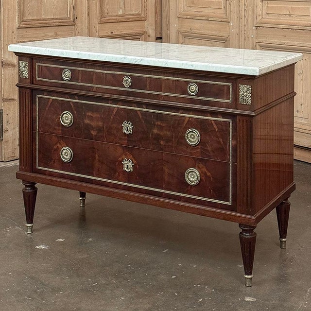 Antique French Louis XVI Mahogany Commode with Carrara Marble is a stunning testament to impeccable style! Hand-crafted...