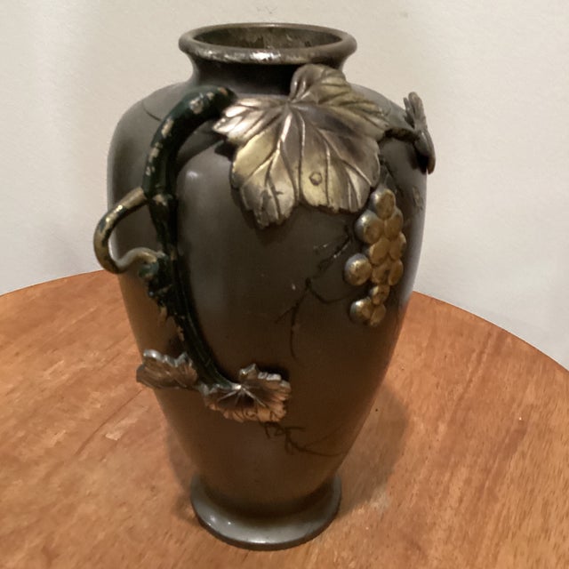This vintage Japanese mixed-metal bronze vase features a high relief applied grapevine motif, adding a touch of elegance...