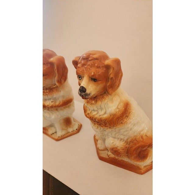 This listing features a pair of ceramic Staffordshire Spaniels with gold detailing and glass eyes. These guarding dogs...