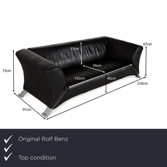 The 322 sofa by Rolf Benz is upholstered in black leather and stands on metal legs that extend diagonally from the sofa....