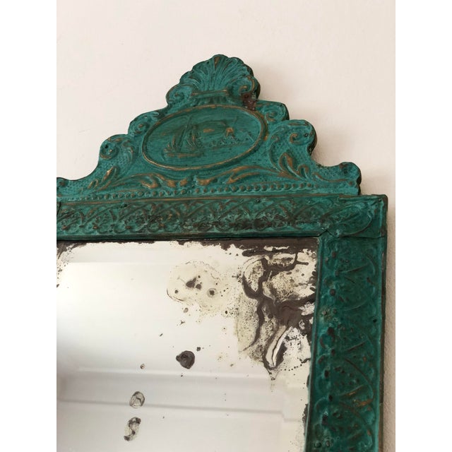 This hand-hammered brass tole wall mirror features a green finish with gold highlights and an ornate relief pattern,...
