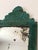This hand-hammered brass tole wall mirror features a green finish with gold highlights and an ornate relief pattern,...