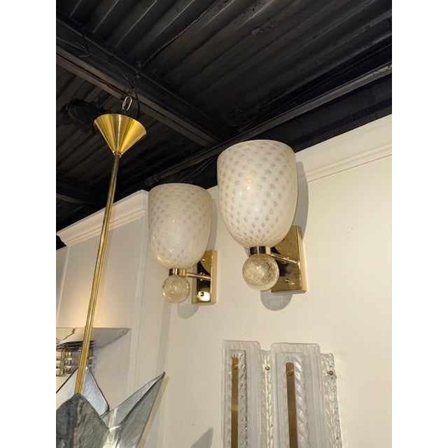 The Modern Cone Form Murano Glass and Brass Sconces feature a sleek and elegant design suitable for contemporary spaces....