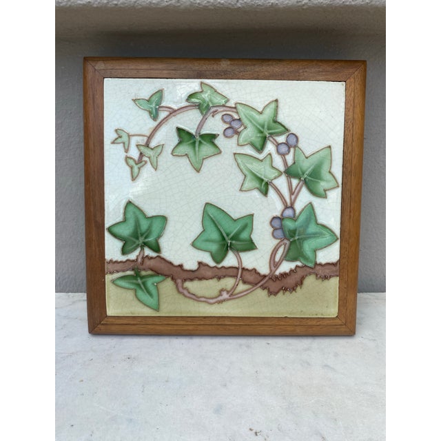 Art Nouveau Majolica trivet in a footed wood frame, circa 1900. ivy pattern. 7.5" by 7.5"