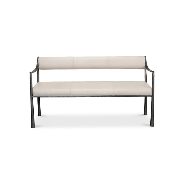 Industrial modern bench with a hand-hammered iron frame in a gunmetal finish with Napa off-white leather cushions. A...