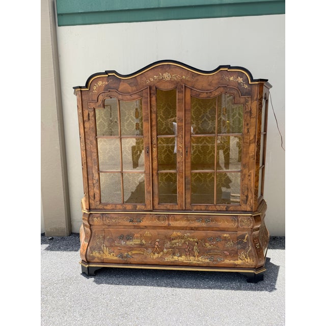 A two-piece sideboard, the upper part with showcase glass doors and sides within a structure with painted Gold leaf...
