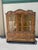 A two-piece sideboard, the upper part with showcase glass doors and sides within a structure with painted Gold leaf...
