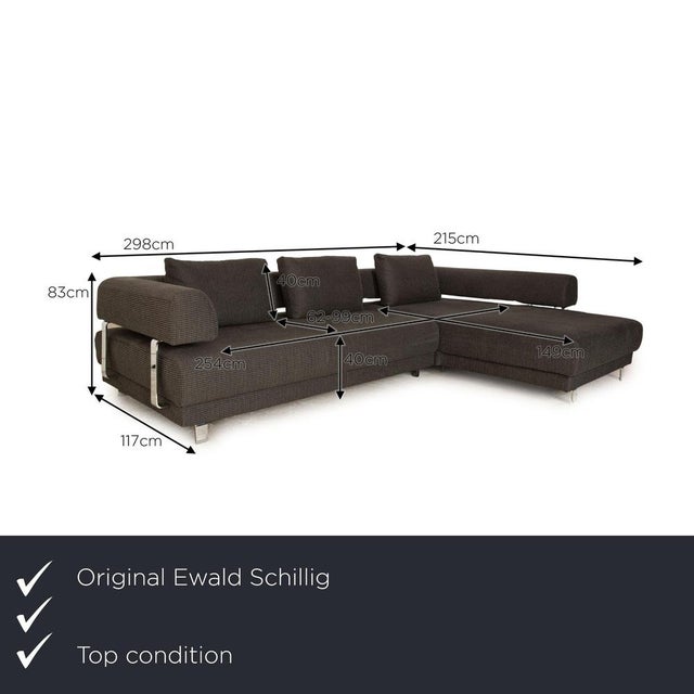 The Brand Face Sofa by Ewald Schillig is covered in a gray fabric and stands on metal feet. The classic design...