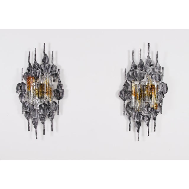 Imposing brutalist wrought iron wall sconces by tom ahlstrom and hans ehrich, circa 1970, each topped with a thick,...