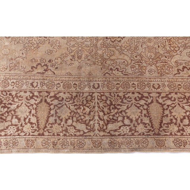 A late 19th century antique North Indian Amritsar rug on a soft brown field framed by a darker brown border with exotic...
