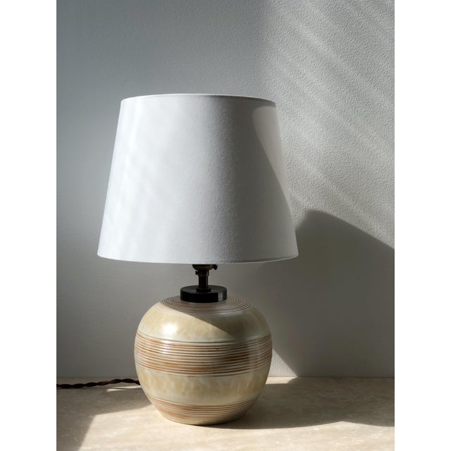 Swedish modern art deco stoneware table lamp with a striped pattern in yellow and brown tones. Glossy gold-brown and...
