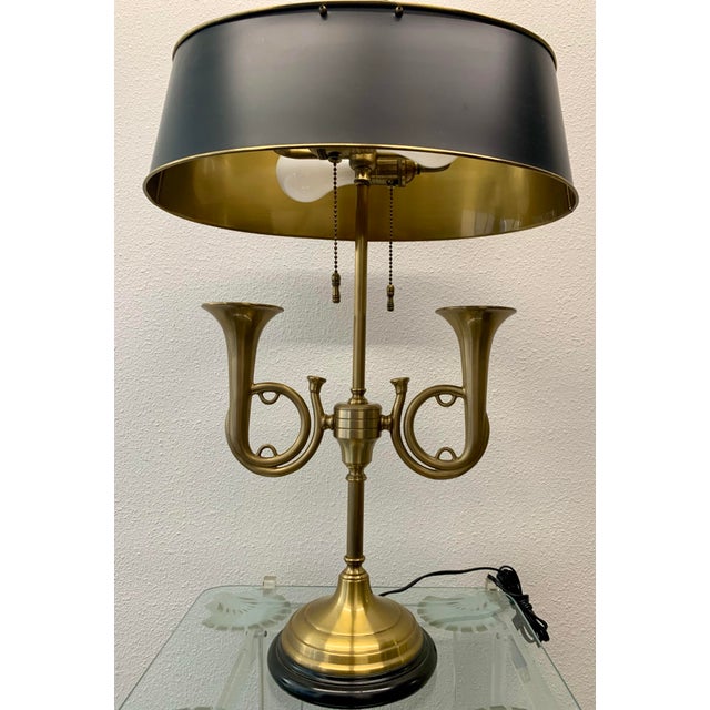 A sophisticated mid-to-late 20th-century bouillotte lamp featuring two gracefully curved, hand-finished brass French horn...