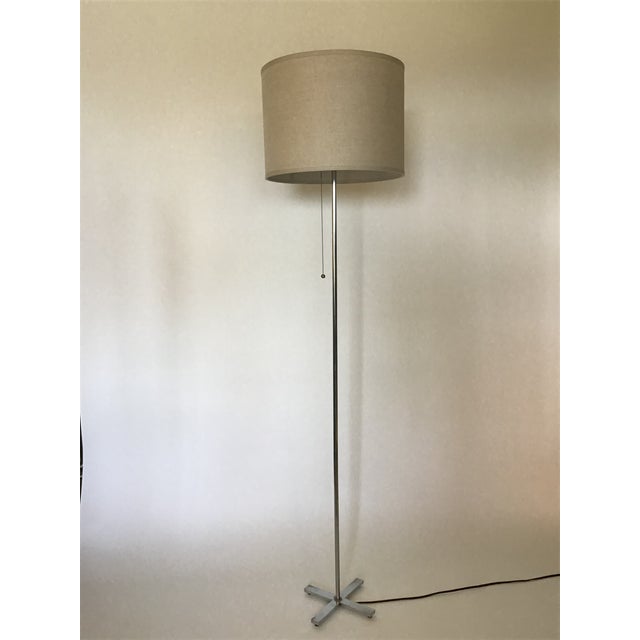 Sleek and timeless, this mid-century modern floor lamp features a polished chrome base with a minimalist X-shaped design,...