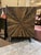 Striking rough-hewn wood cabinet crafted circa 2010s–2020s in the Rustic Modern / Industrial style, featuring a dramatic...
