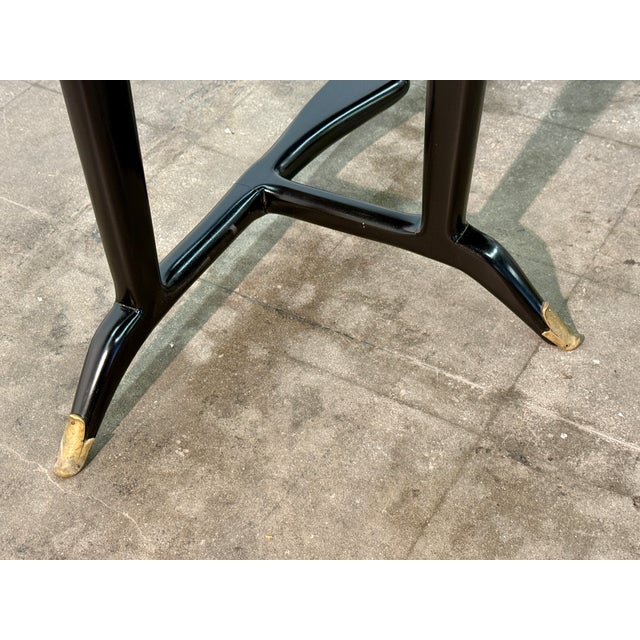 Elegant Italian console table attributed to Paolo Buffa, dating to the 1950s. The sculptural black lacquered wood frame...
