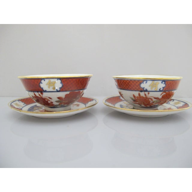 A stunning pair of Japanese Imari porcelain cups/bowls with matching saucers. Crafted from fine white porcelain, each...