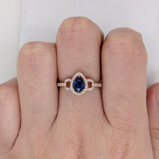 A Ceylon sapphire glows in a bright cornflower blue at the centre of this solid 14K yellow gold ring, encircled by forty-...